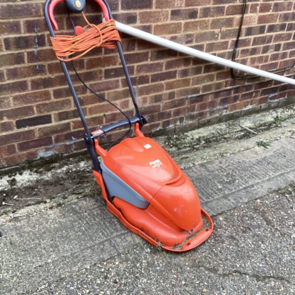 Vintage Flymo hover mower in a garden setting.