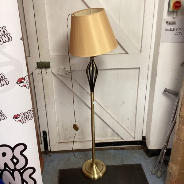 Vintage brass standard lamp with cream shade for home lighting.