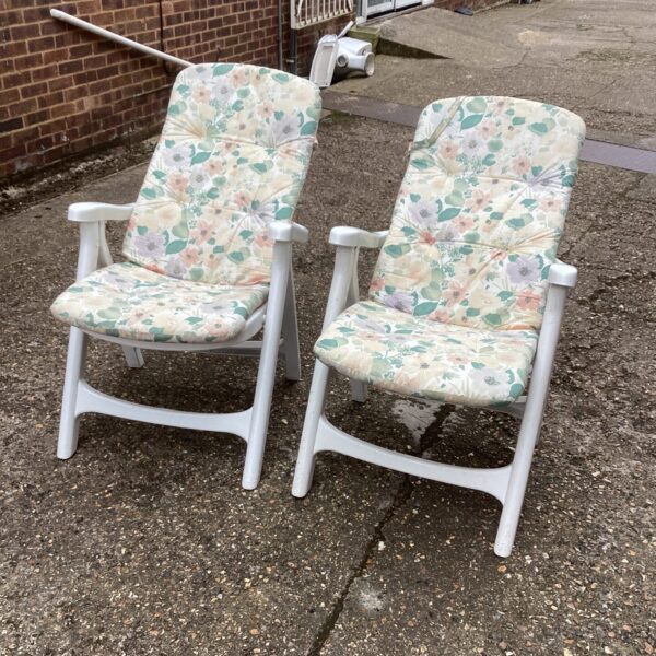 Vintage pair of plastic garden chairs with patterned cushions.