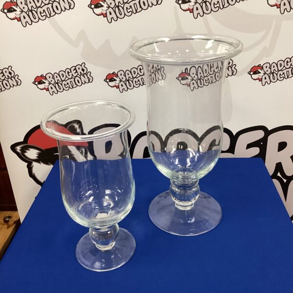 Two clear glass candle vases for home decor.