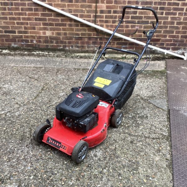 Red Champion petrol lawn mower for garden maintenance.