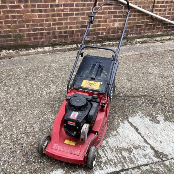 Red Mountfield petrol lawn mower in used condition, ideal for garden maintenance.