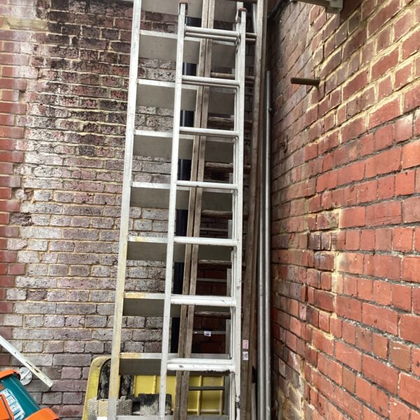Silver Clima double extension ladder leaning against a brick wall.