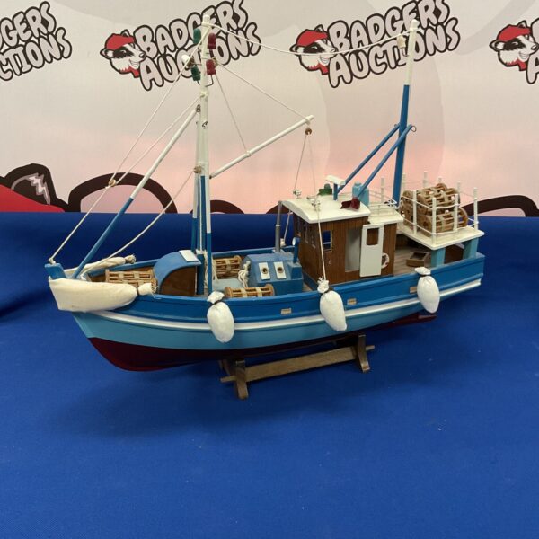 Detailed wooden lobster boat model with miniature traps.