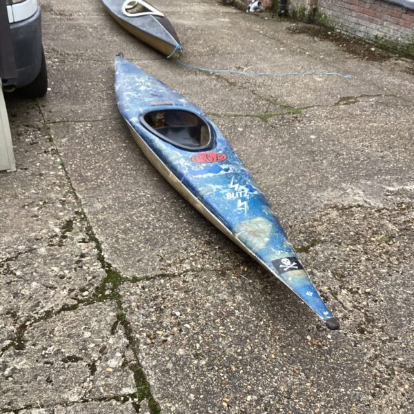 Blue and orange Bliz Canoe on a paved surface.