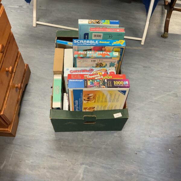 Crate filled with a mixed lot of board games and jigsaw puzzles.