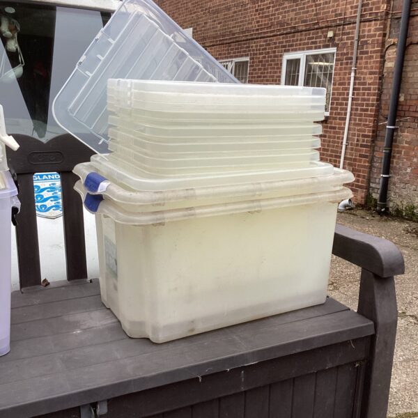 Clear plastic storage containers stacked, ideal for household organisation.