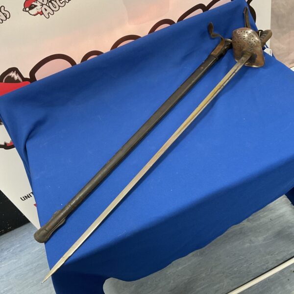 Antique WW1 cavalry sword with scabbard on a blue background.
