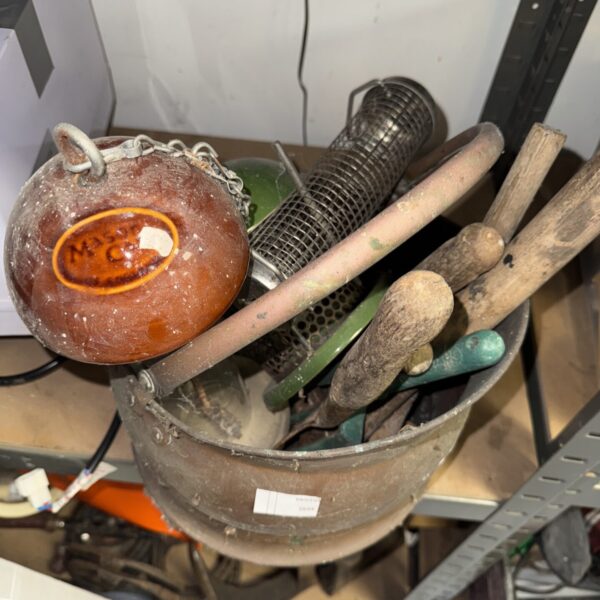 Vintage copper coal bucket with garden tools inside.