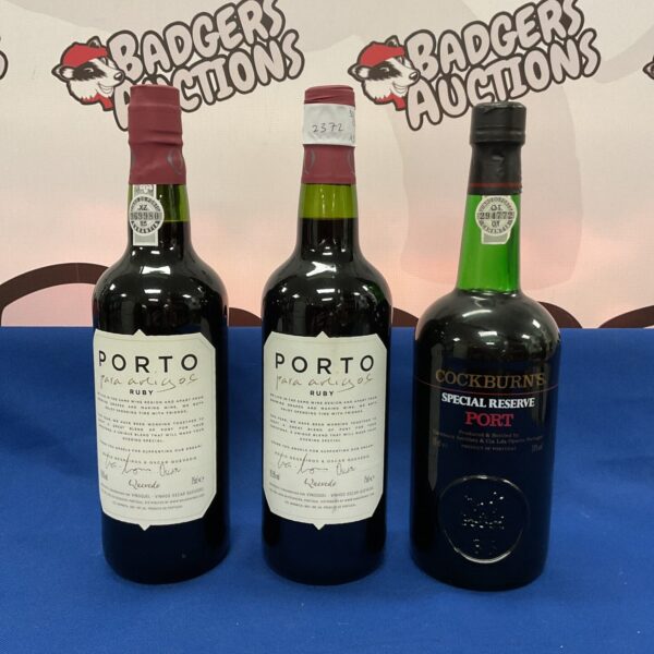 Collection of three port wine bottles, including Cockburn's and Para Amigos.