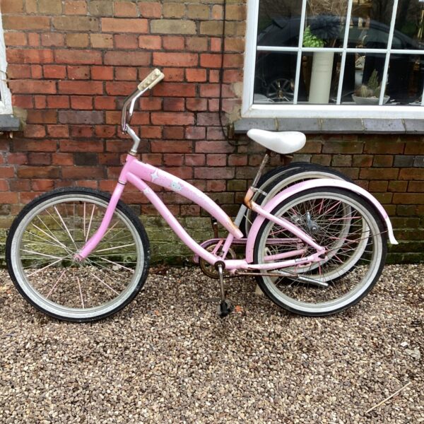 Pink Hello Kitty California cruiser bicycle with white saddle.