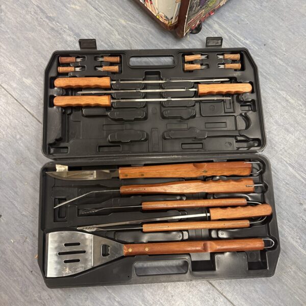 Black carrying case containing a vintage BBQ utensil set.