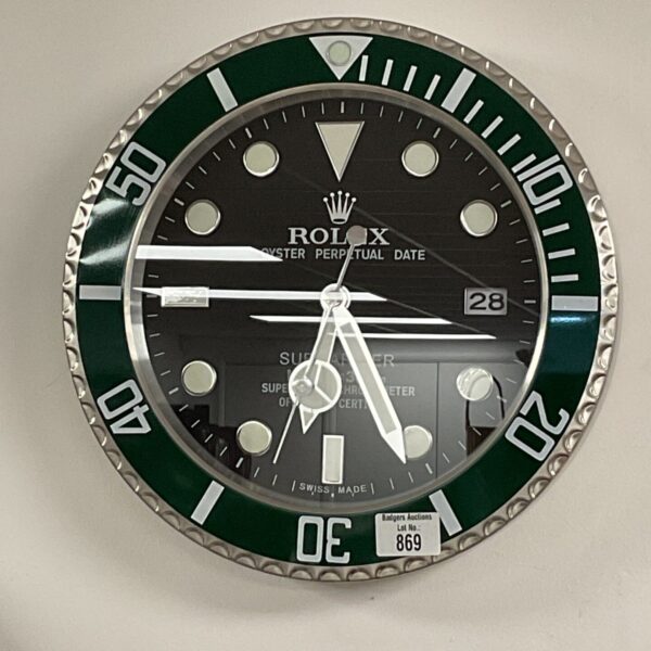 Front view of a black and white Rolex style wall clock.