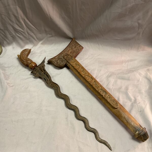 Vintage Indonesian kris dagger with wavy blade and carved hilt.