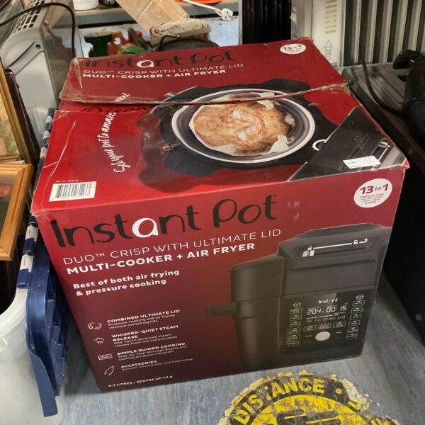 Instant Pot multi cooker with air fryer lid for versatile cooking.