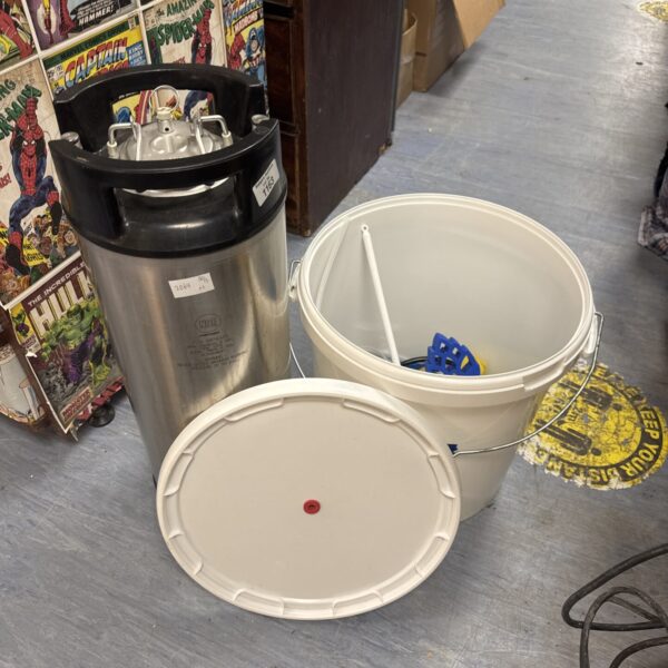 Home brewing kit with stainless steel container and comic books.