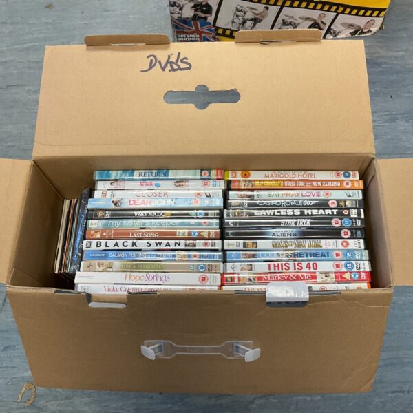 Assorted DVD movies in a cardboard box, a film collection.