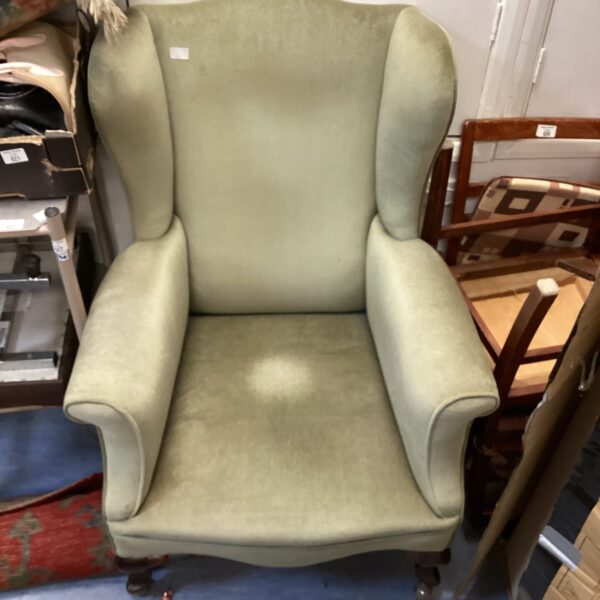 Vintage upholstered wingback chair on casters.