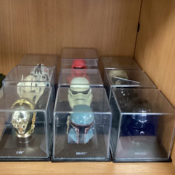 Selection of miniature Star Wars helmets on display stands.