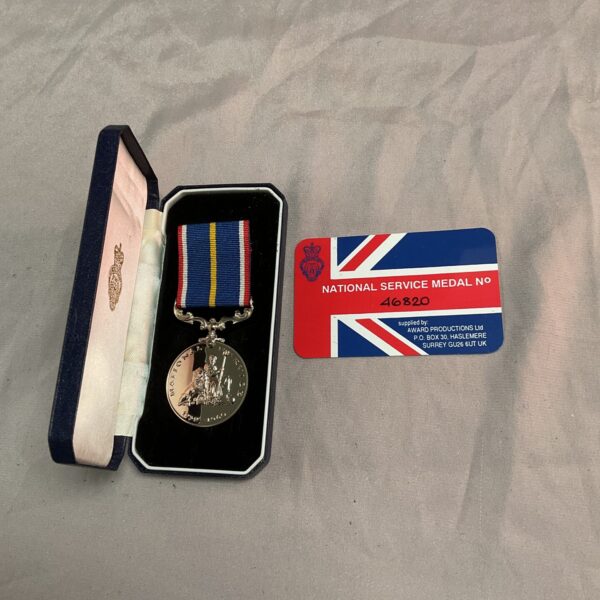 Close-up of National Service Medal number 46820 with ribbon.