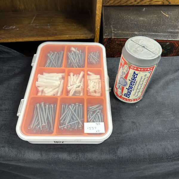 Vintage Budweiser toolkit with screws and rawl plugs on a patterned surface.