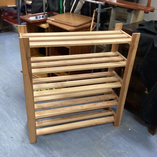 Front view of a rustic pine shelf unit with four shelves.