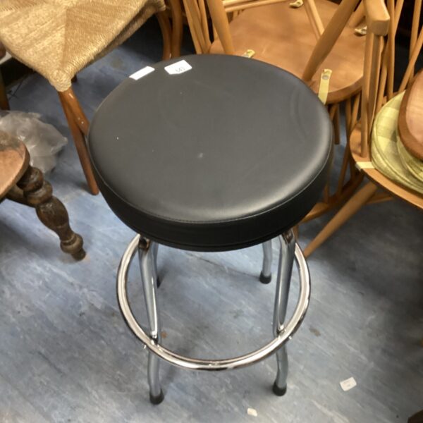 Black swivel stool with chrome base and footrest.