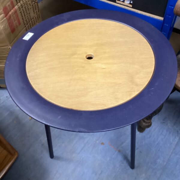 Round metal and wooden table with vintage charm.