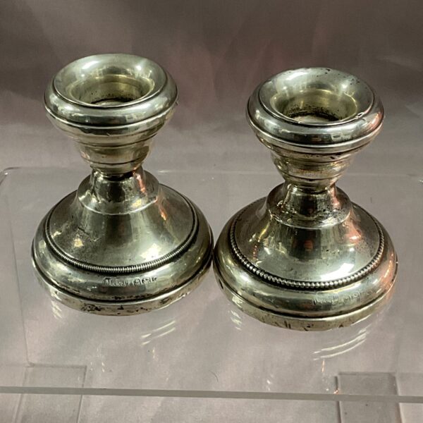 Pair of antique sterling silver weighted candle sticks.