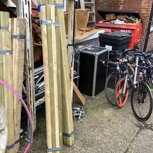 Three bundles of timber in a garden setting.