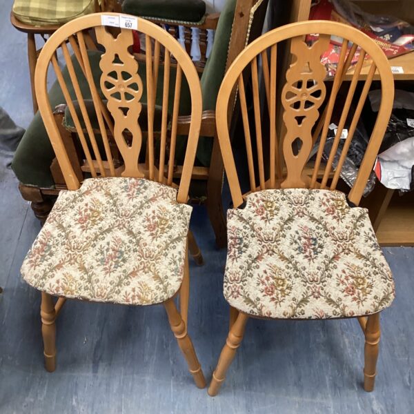 Pair of vintage wheelback dining chairs with patterned seats.