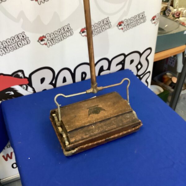 Antique Ewbank carpet sweeper with wooden body and long handle.