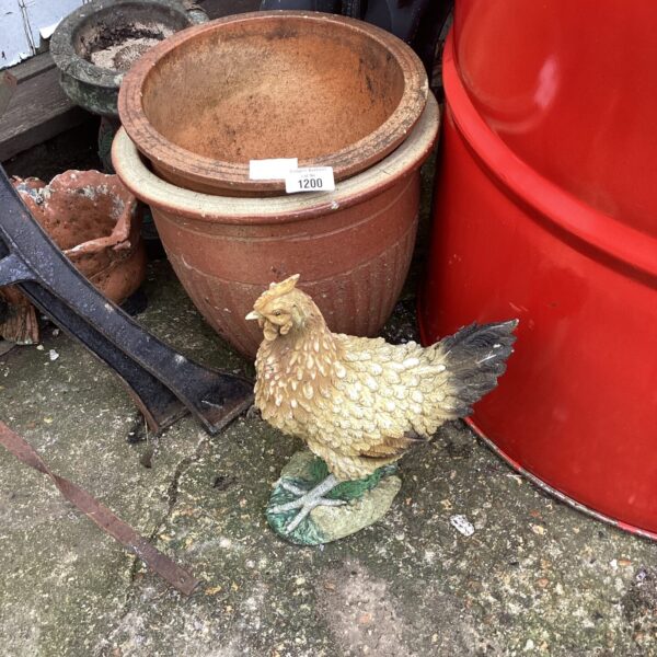 Vintage garden chicken ornament with terracotta pots.