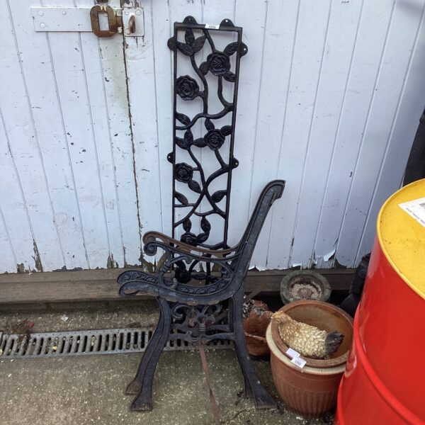 Antique wrought iron garden bench ends with floral details.