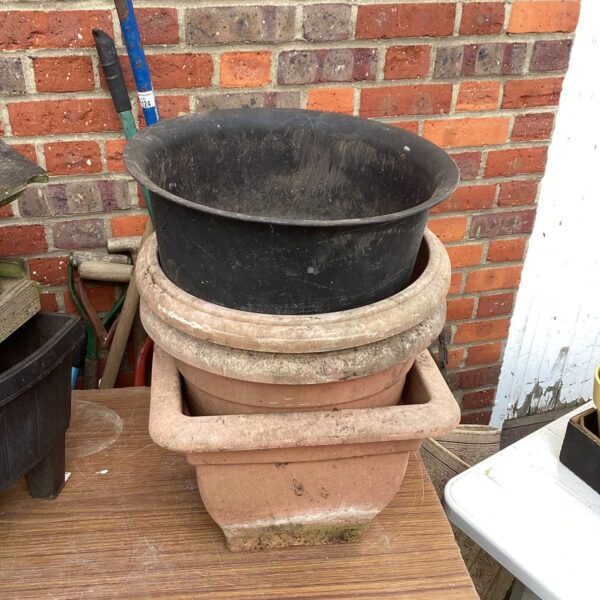 Lot of plastic garden planters in terracotta and green.