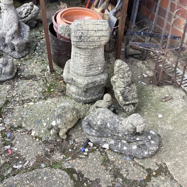 Vintage concrete garden otter ornament in a garden setting.