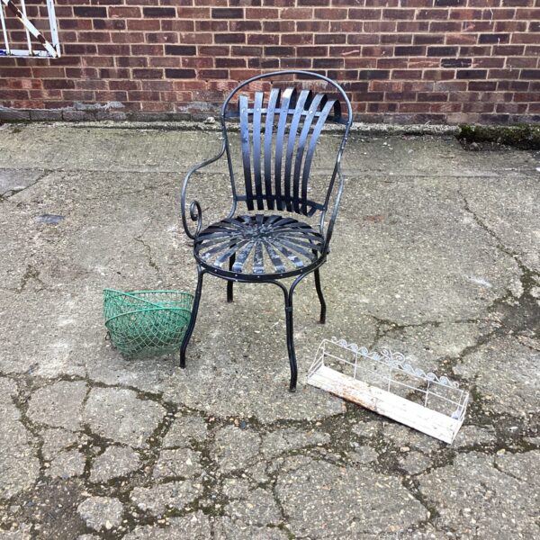Vintage metal garden chair with flower baskets in a garden setting.