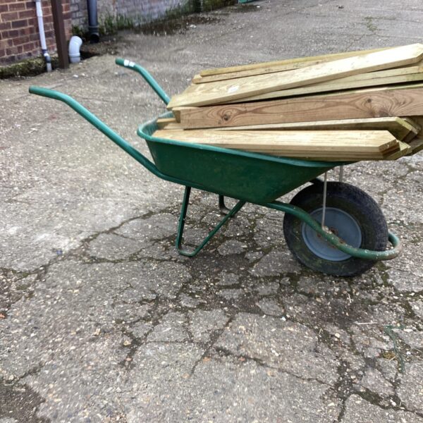 Heavy duty steel wheelbarrow with load of wood.
