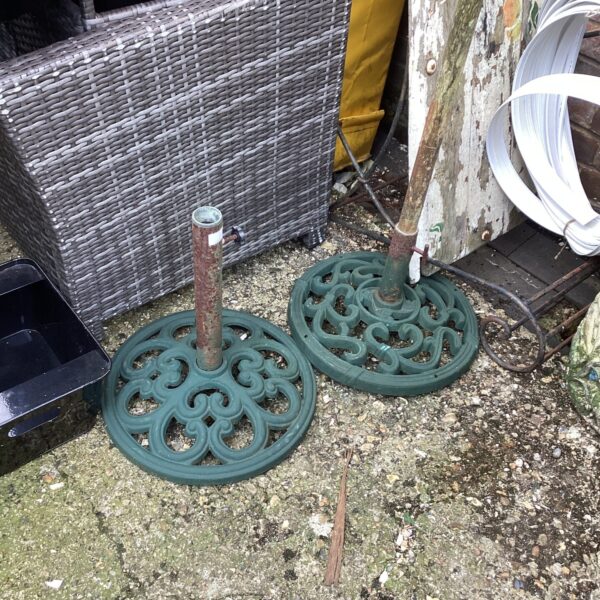 Pair of vintage metal parasol bases for garden use.