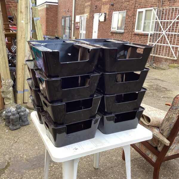 Quantity of metal storage boxes stacked on a white surface.
