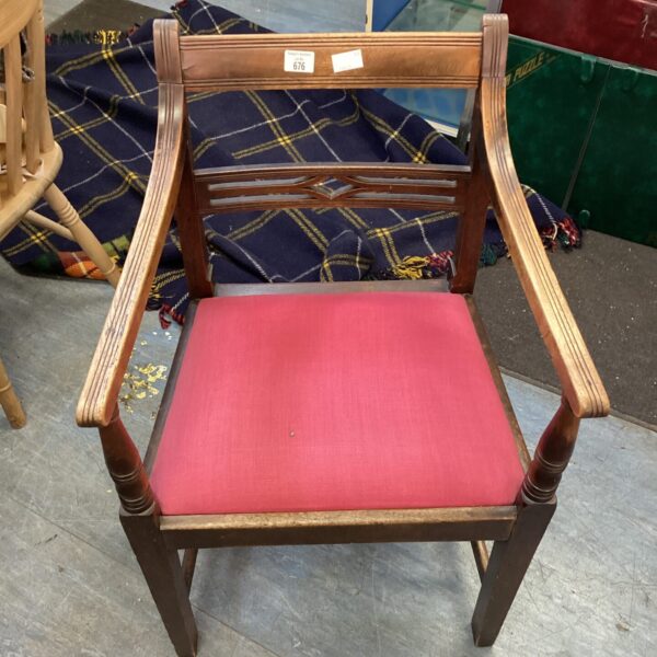 Vintage oak carver chair with red upholstery and carved details.