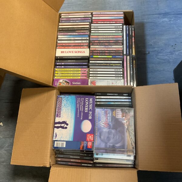 Two boxes filled with a diverse CD music collection.