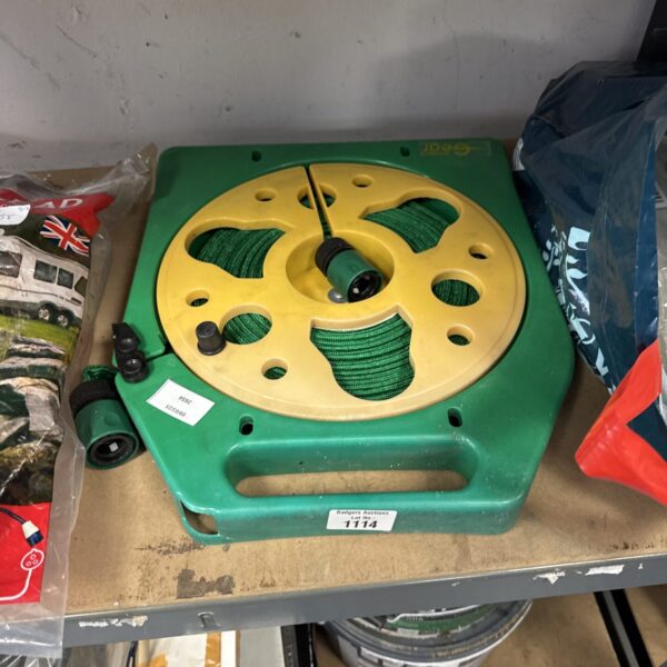 Green retractable garden hose reel for outdoor garden use.