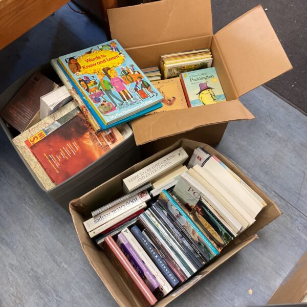 Mixed lot of vintage children's books and cookbooks on display.