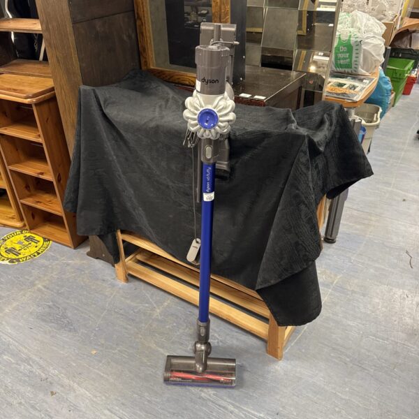 Dyson V6 Fluffy cordless vacuum cleaner with charger and cradle.