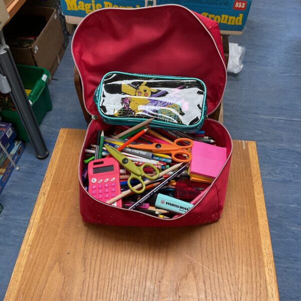 Colourful pencil case filled with stationery and school supplies.