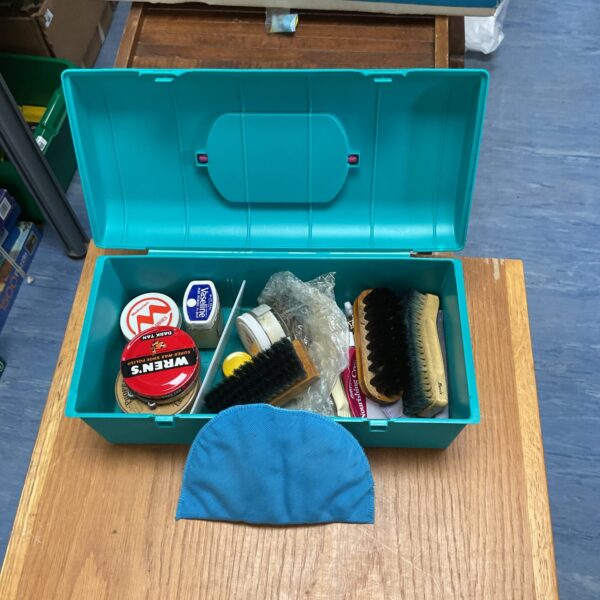 Vintage blue tin shoe cleaning kit with brushes and polishes.