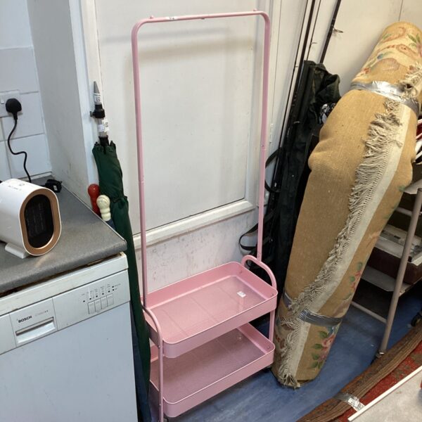 Pink metal storage rack with three tiers, ideal for kitchen or bathroom.