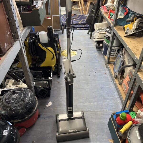 Gtech Air Ram cordless vacuum cleaner in a cluttered space.