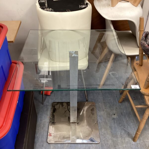 Modern glass bistro table with chrome base for kitchen dining.